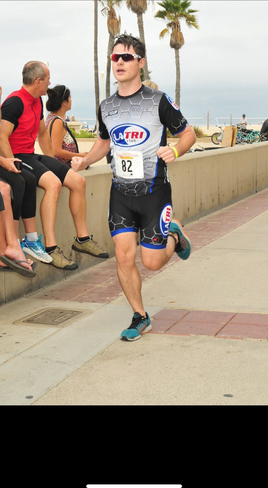 Joel Olson running the closing leg of a triathlon in a LA Tri Club race kit.