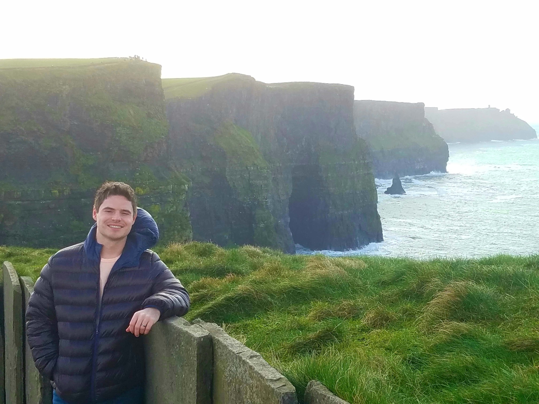 Portrait of Joel Olson outdoors at the Cliffs of Moher in Ireland.